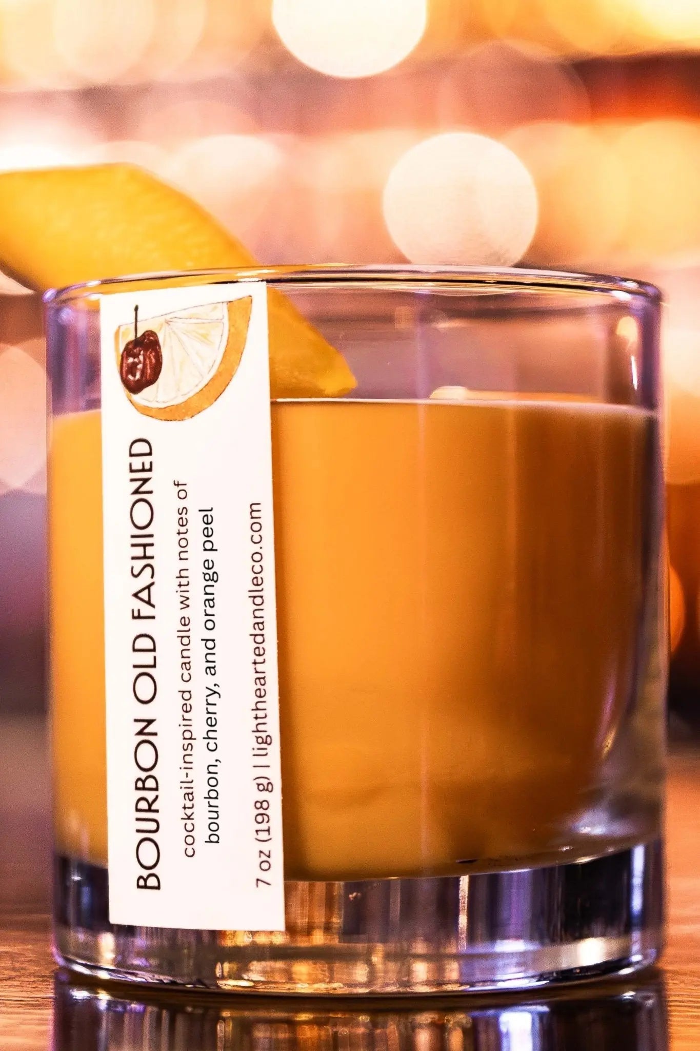Close-up of Bourbon Old Fashioned Candle with orange peel garnish on the bar