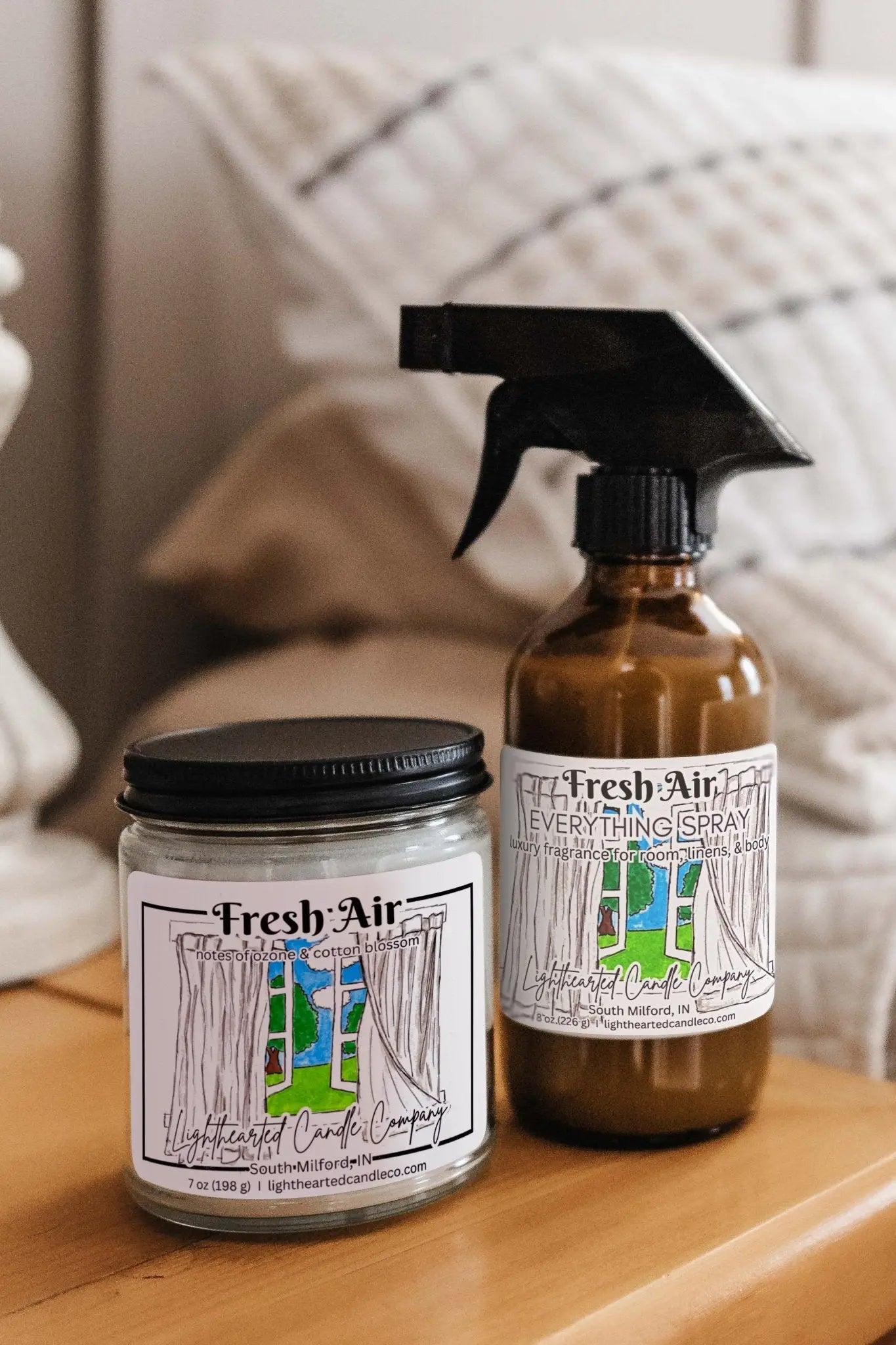 Fresh Air Candle and matching Everything Spray styled on a bedside table