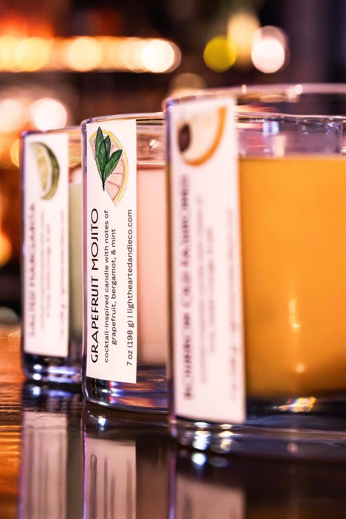Close-up of Grapefruit Mojito Candle with grapefruit garnish on the bar