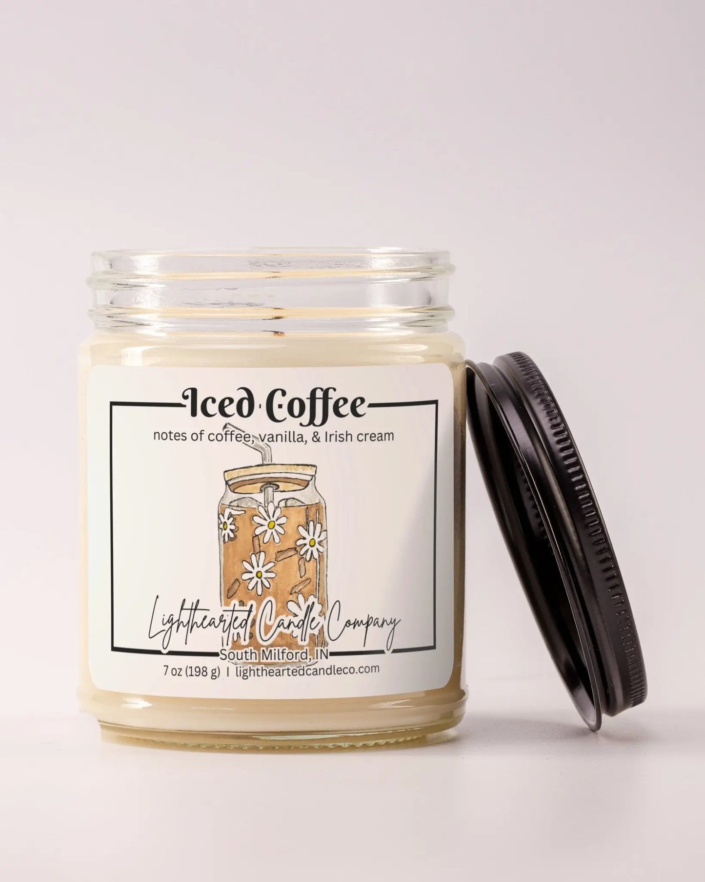 Unlit Iced Coffee Candle in a clear glass jar with its black lid beside it