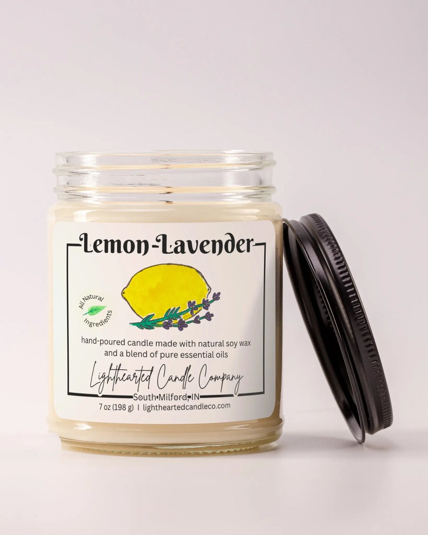 Unlit Lemon Lavender Essential Oil Candle in a clear glass jar with its black lid beside it