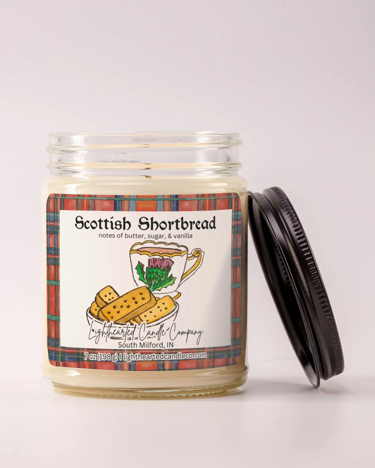 Unlit Scottish Shortbread Candle in a clear glass jar with its black lid beside it
