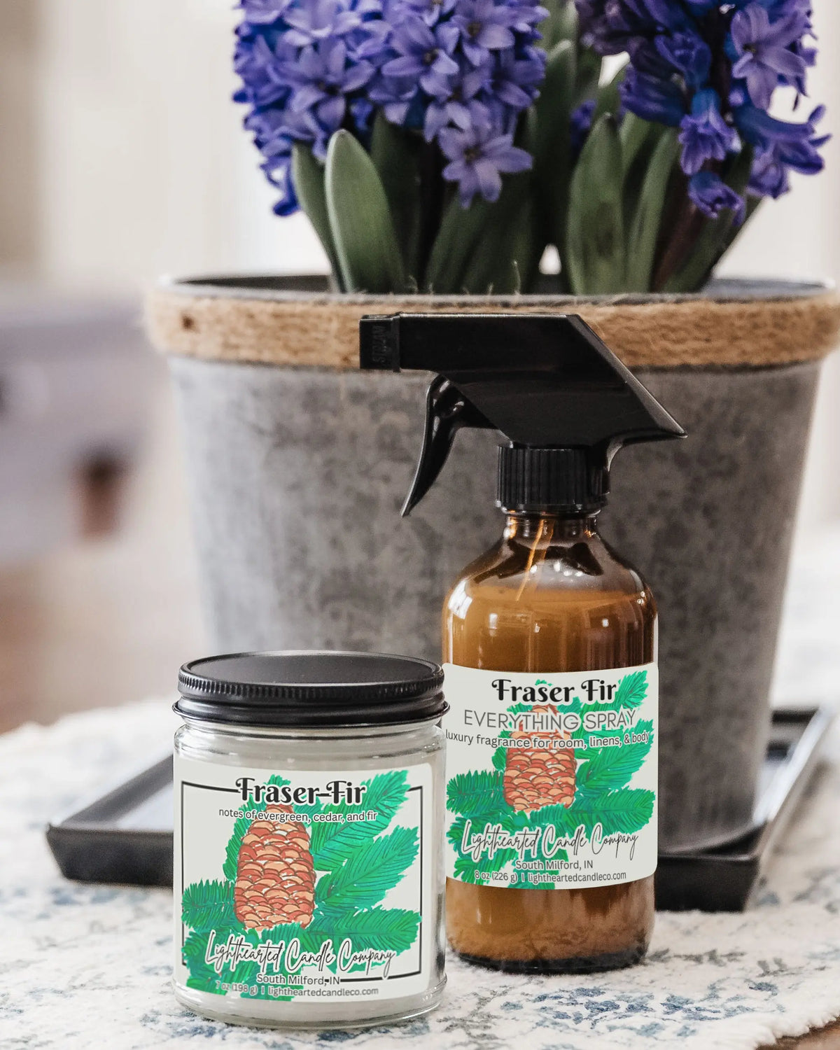 Closed Fraser Fir Candle in a clear glass jar with a black metal lid