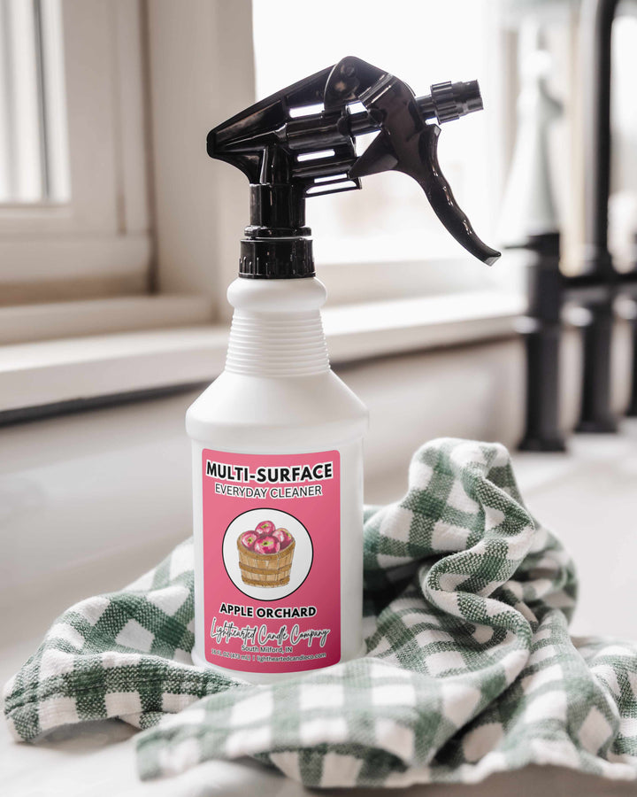 Apple Orchard Cleaning Spray in a white trigger bottle beside a green checkered towel