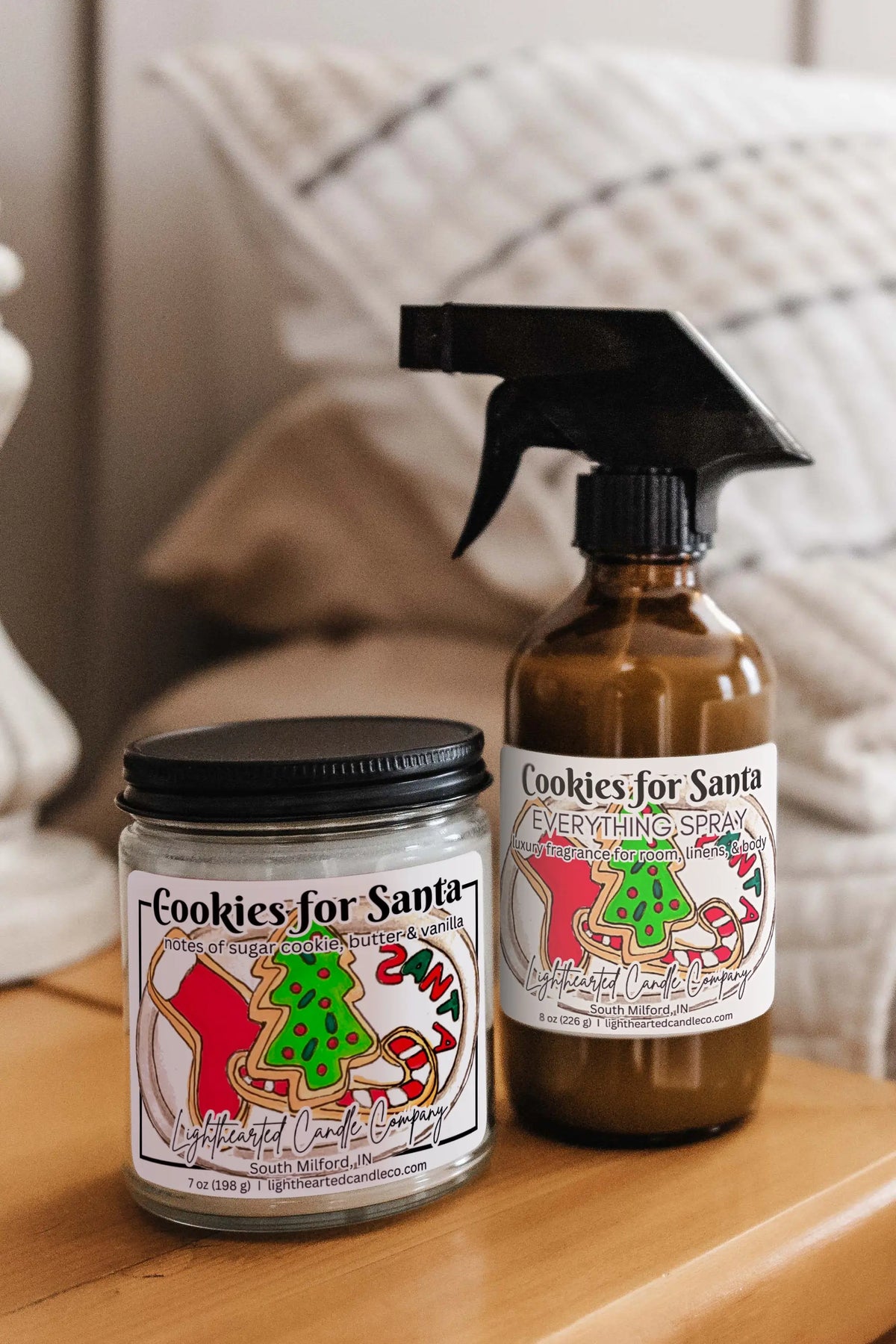 Matching candle and Cookies for Santa Everything Spray styled on a bedside table