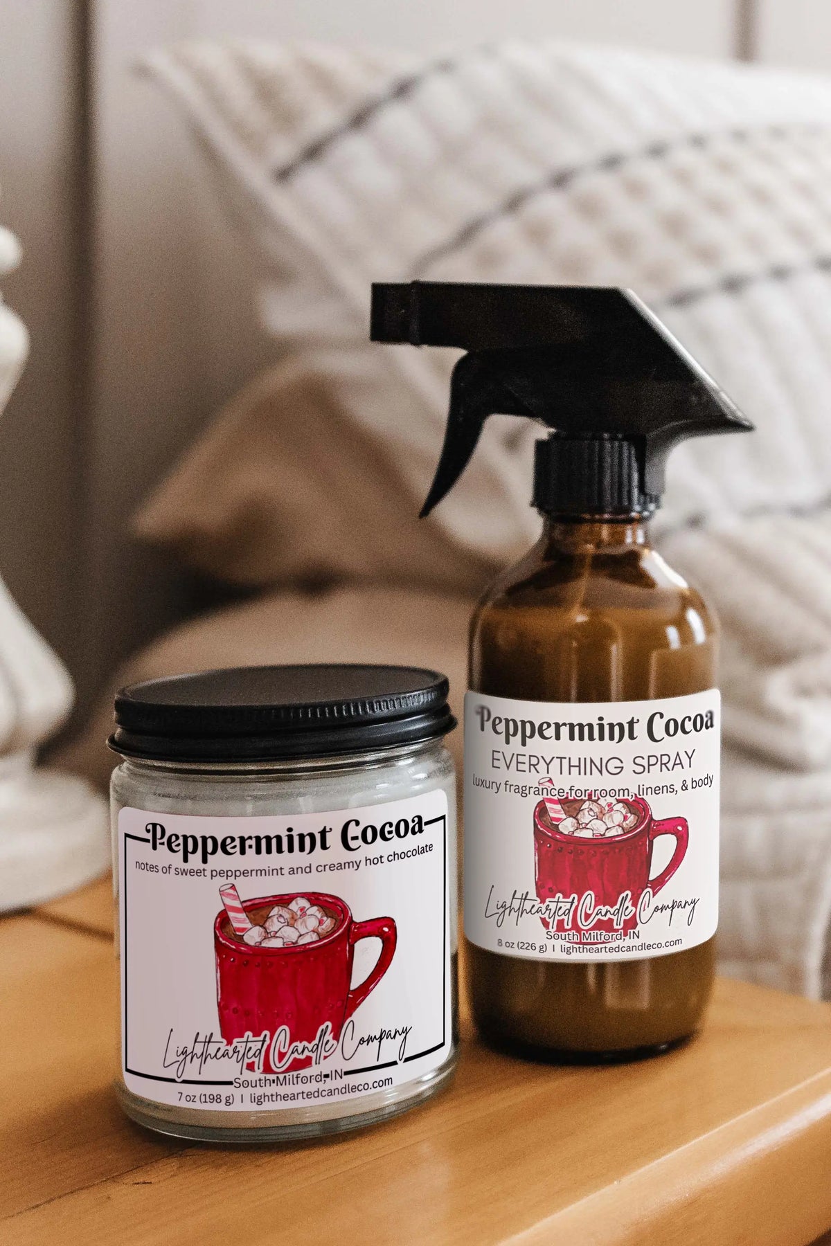 Matching candle and Peppermint Cocoa Everything Spray styled on a bedside table