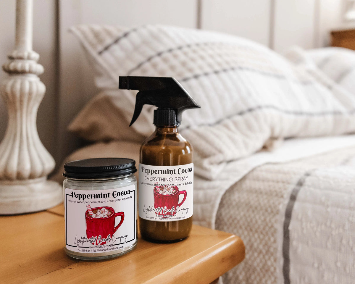 Peppermint Cocoa candle and Everything Spray styled on a bedside table
