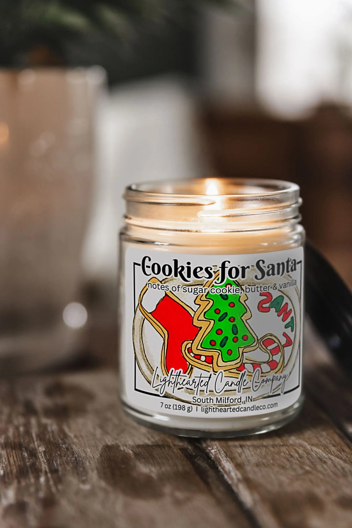 Lit Cookies for Santa Candle in a clear glass jar on a rustic wooden table