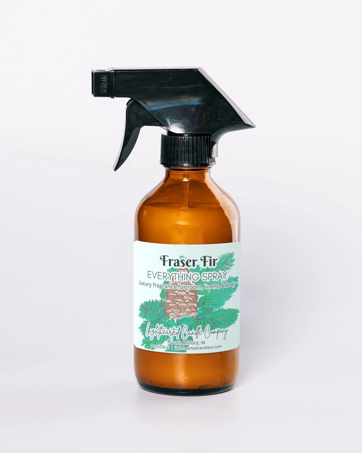 Fraser Fir Everything Spray in an amber glass bottle in a styled indoor setting