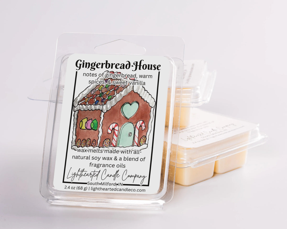 Gingerbread House Wax Melt clamshells arranged in a stack on a pale background
