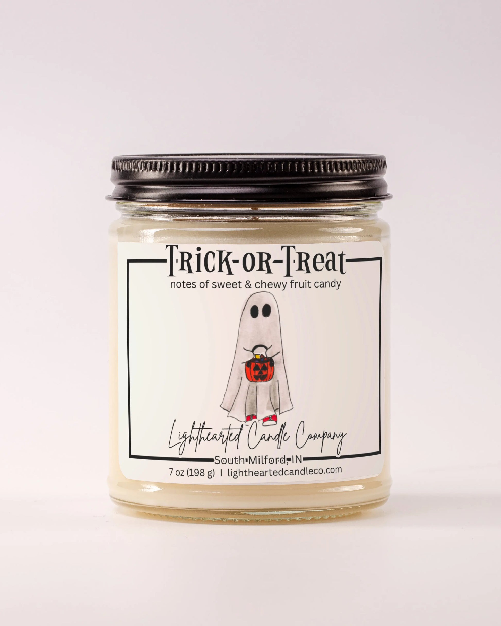 Closed Trick or Treat Candle in a clear glass jar with a black metal lid