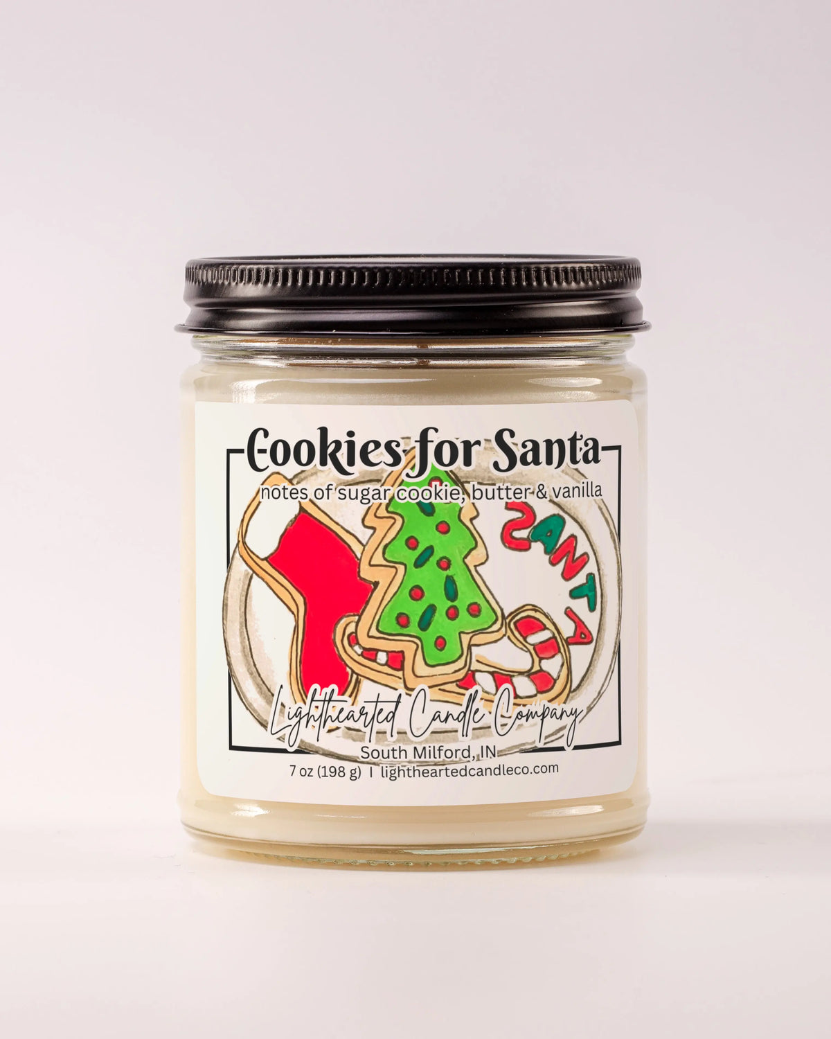 Unlit Cookies for Santa Candle in a clear glass jar with its black lid beside it