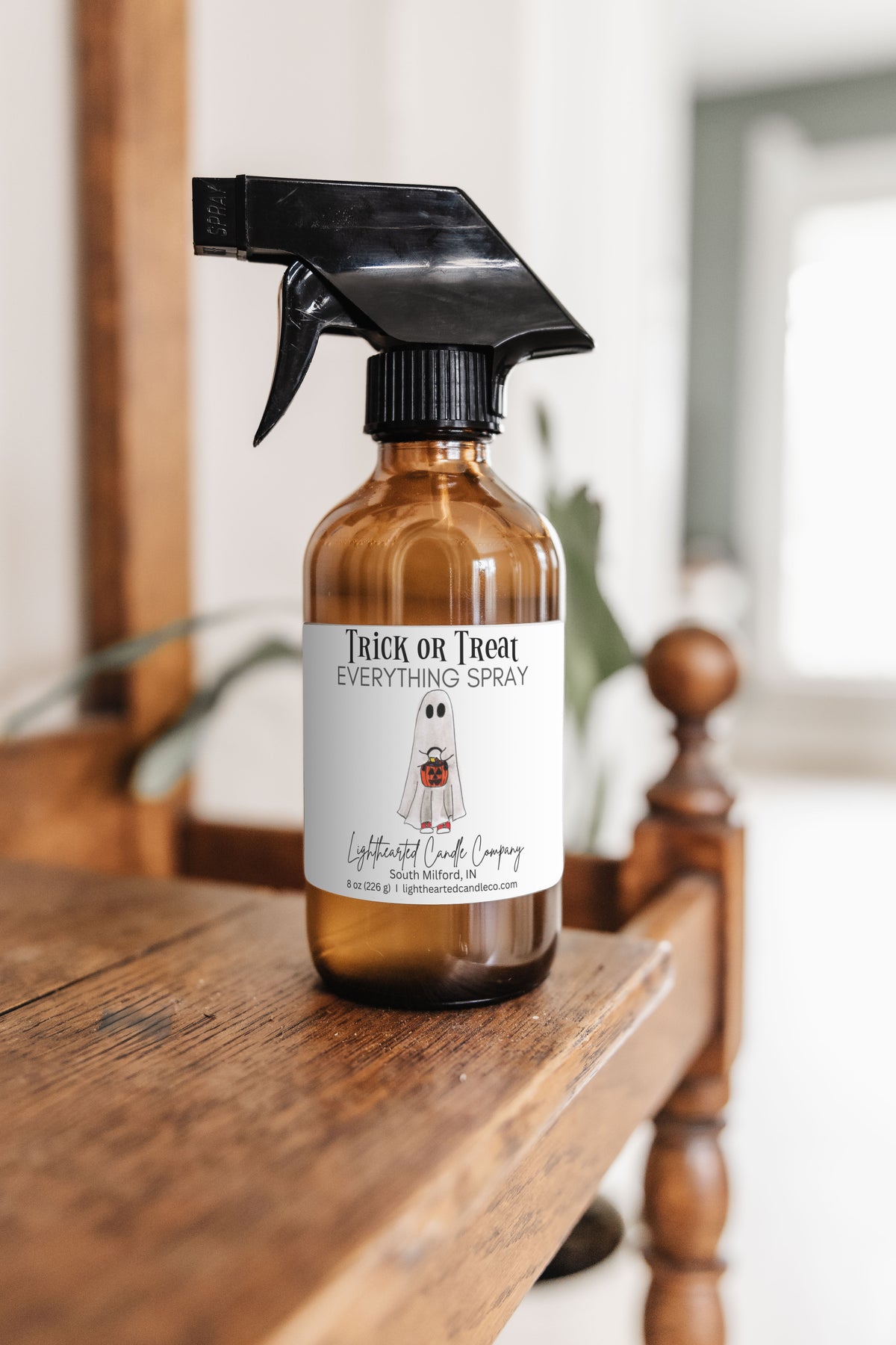 Trick or Treat Everything Spray in an amber glass bottle in a styled indoor setting