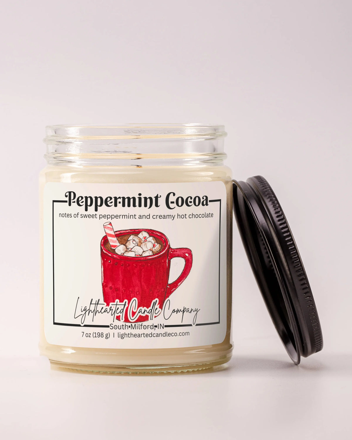 Unlit Peppermint Cocoa Candle in a clear glass jar with its black lid beside it