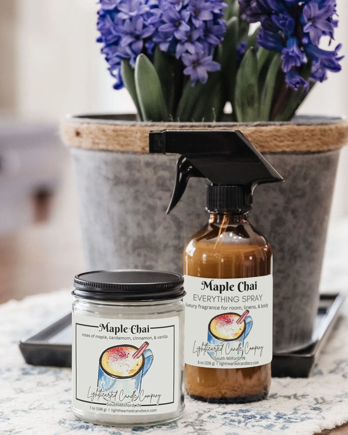 Closed Maple Chai Candle in a clear glass jar with a black metal lid