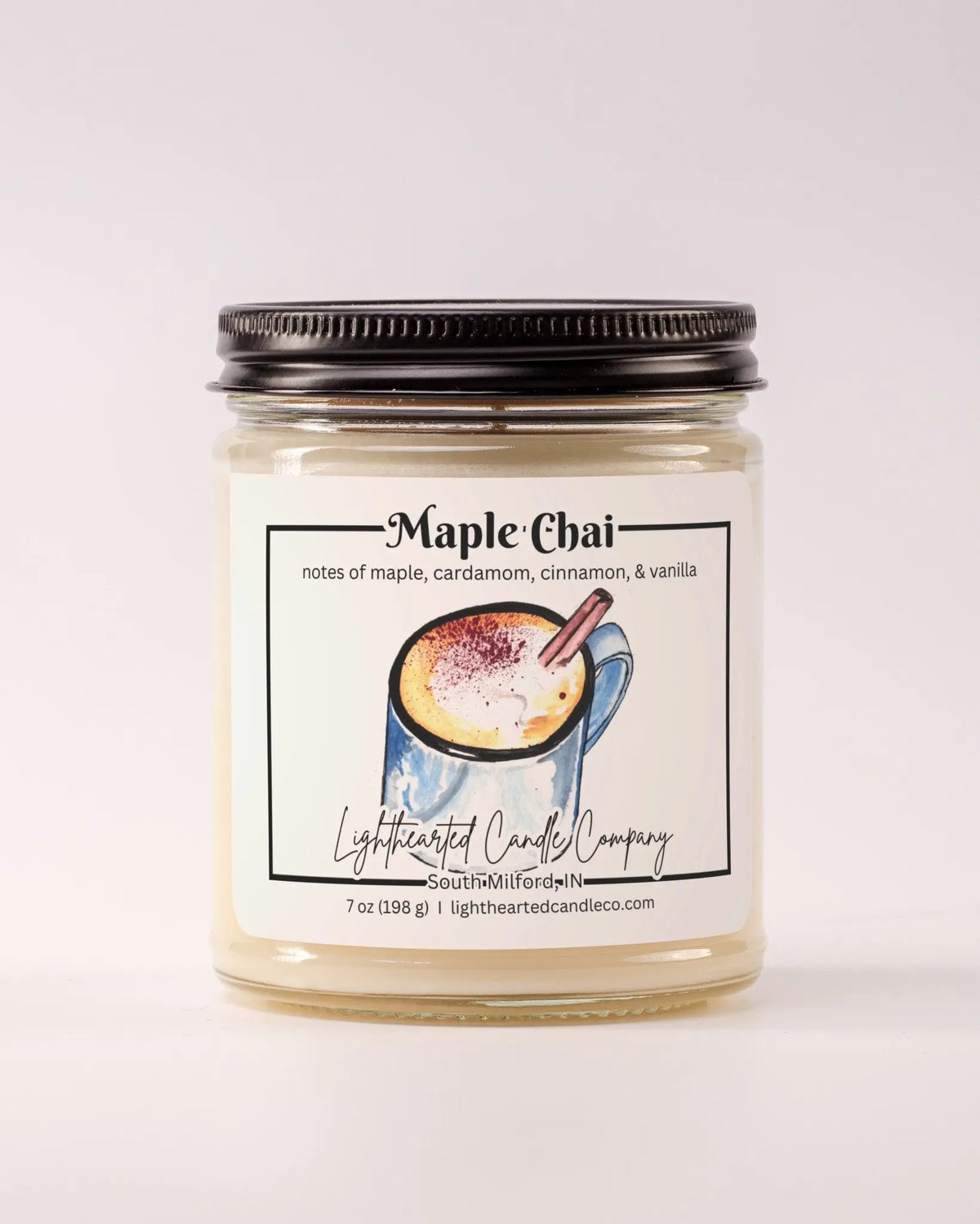 Unlit Maple Chai Candle in a clear glass jar with its black lid beside it