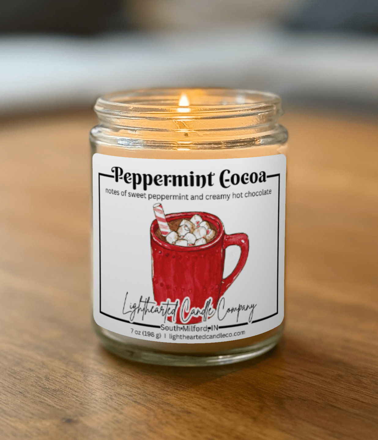 Candle in a glass jar with a peppermint cocoa label on a wooden surface